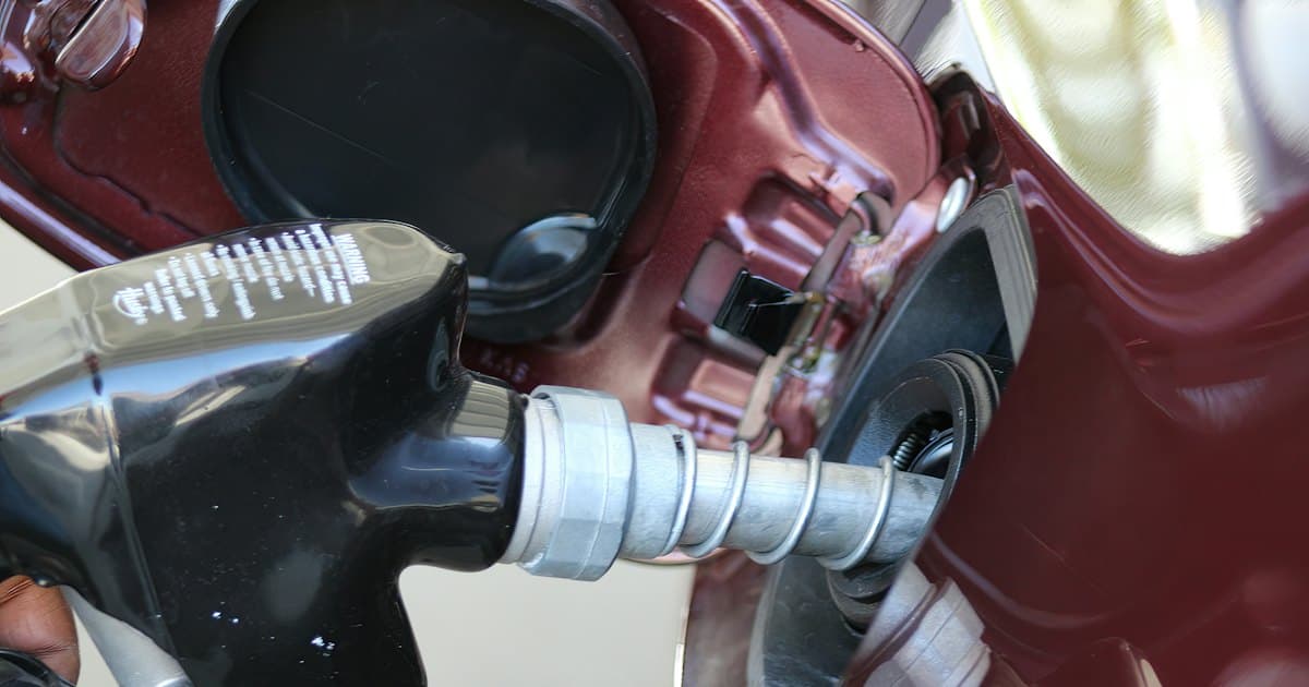 Close-up of a fuel nozzle filling a car's gas tank.